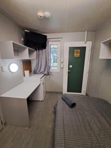Kleines Zimmer mit einem Schreibtisch und einer grünen Tür in der Unterkunft Cooktown Fishing Haven in Cooktown
