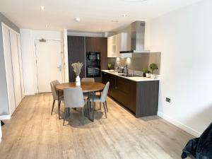 a kitchen and dining room with a table and chairs at 2 bedroom Apartment in Manchester