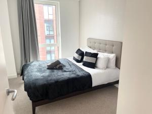 a bedroom with a bed with pillows and a window at 2 bedroom Apartment in Manchester