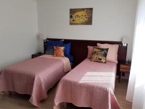 two beds sitting next to each other in a room at Petite maison rénovée proche centre Lunéville, jardin, barbecue, parking privatif, à 30 min de Nancy - FR-1-584-180 in Lunéville