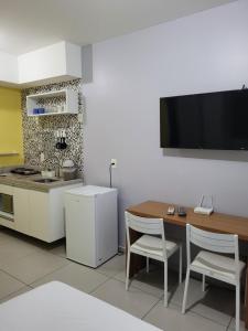 eine Küche mit einem Tisch und einem TV an der Wand in der Unterkunft Lindo Studio no Centro SP - Próximo 25 Março in São Paulo
