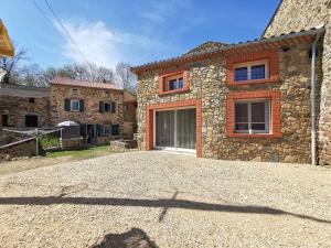 a stone house with a driveway in front of it at Charmant Gîte Rénové avec Sauna en Haute-Loire, Parfait pour Randonnées et Repos - FR-1-582-344 in Saint-Just-près-Brioude