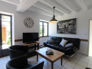 a living room with a couch and a table at Gîte moderne avec piscine en Anjou, proche Saumur et Cholet, idéal pour familles et groupes - FR-1-622-30 in Vihiers