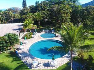 - une vue sur la piscine bordée de palmiers dans l'établissement Flat Incrível - Livyd Angra dos Reis - Hotel do Bosque 3p, à Angra dos Reis