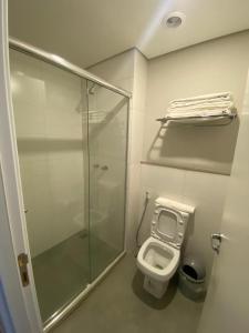 La salle de bains est pourvue de toilettes et d'une douche en verre. dans l'établissement Flat Incrível - Livyd Angra dos Reis - Hotel do Bosque 3p, à Angra dos Reis