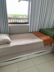 uma cama num quarto com uma janela em Apartamento Barra Bali Resort em Barra de São Miguel