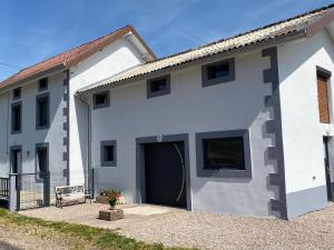 un edificio blanco con una puerta grande en la parte delantera en Gîte Plombières-les-Bains, 4 pièces, 5 personnes - FR-1-589-432, en Plombières-les-Bains