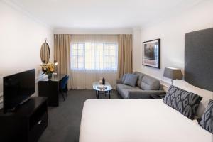 una camera d'albergo con letto e divano di Peppers The Hills Lodge a Castle Hill