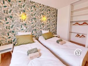 2 camas en una habitación con papel pintado en Gîte Saulges, 6 pièces, 10 personnes - FR-1-600-222 en Saulges