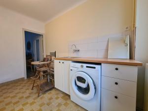 eine Küche mit einer Waschmaschine und einem Tisch in der Unterkunft Gîte Saint-Marcel, 4 pièces, 7 personnes - FR-1-591-444 in Saint-Marcel