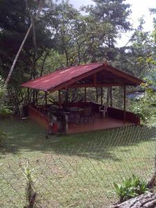 een paviljoen met een tafel en stoelen in een tuin bij Mountain Chalet in Los Altos de Cerro Azul