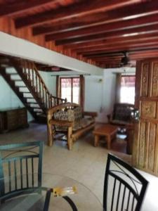 a living room with a table and chairs and stairs at Mountain Chalet in Los Altos de Cerro Azul