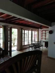 - un salon avec une table, des chaises et des fenêtres dans l'établissement Mountain Chalet, à Los Altos de Cerro Azul