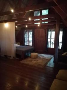 1 dormitorio con 1 cama en una habitación con ventanas en Mountain Chalet, en Los Altos de Cerro Azul