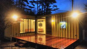 una pequeña casa con terraza por la noche en アイアンネスト en Fujikawaguchiko