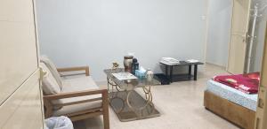 een woonkamer met een bed, een tafel en een stoel bij HOUSE IN AL AIN - 3 in Al Ain