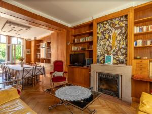 un soggiorno con camino e tavolo di Manoir 19e 7 chambres, piscine chauffée, parc arboré proche lac en Champagne - FR-1-611-95 a Montier-en-Der