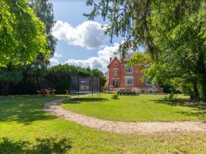 un parco con parco giochi di fronte a una casa di Manoir 19e 7 chambres, piscine chauffée, parc arboré proche lac en Champagne - FR-1-611-95 a Montier-en-Der