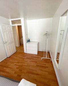 een kamer met een houten vloer en een witte deur bij Lovely 2-bed 20 mins to central London in Londen