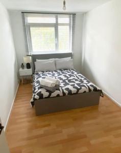 een slaapkamer met een bed met een zwart-wit dekbed bij Lovely 2-bed 20 mins to central London in Londen