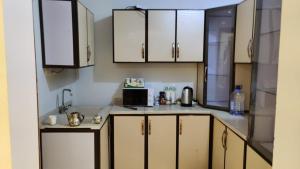 a kitchen with white cabinets and a microwave at Fatih Hostel for Males in ‘Urwah