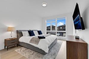 1 dormitorio con 1 cama grande y TV en Townhome with Spa in Mirabel - 1 en Mirabel