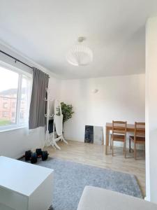a white living room with a table and chairs at Colliers Wood 1 Bed South London Short Stay in Mitcham