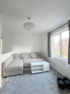 a white living room with a couch and a window at Colliers Wood 1 Bed South London Short Stay in Mitcham