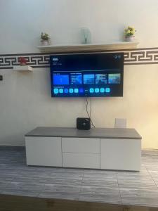 TV de pantalla plana en la parte superior de un armario blanco en RESIDENCE OUAGA en Uagadugú