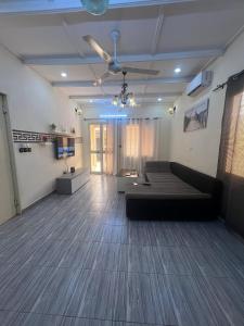 a living room with a couch and a ceiling fan at RESIDENCE OUAGA in Ouagadougou