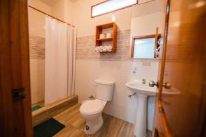 a bathroom with a toilet and a sink at Galápagos Trip in Puerto Ayora