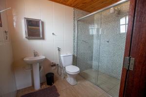 a bathroom with a shower and a toilet and a sink at Casa do Eduardo ibitipoca mg in Conceição da Ibitipoca