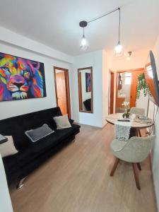 a living room with a black couch and a table at Apt próximo ao Consulado in Porto Alegre