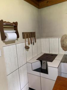 een hoek van een kamer met een tafel en toiletpapier bij Casa de Campo Aconchegante in Quiriri