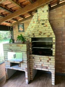 a brick wall with a fireplace in a house at Casa de Campo Aconchegante in Quiriri