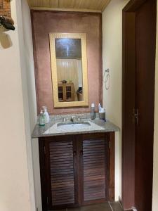 ein Bad mit einem Waschbecken und einem Spiegel in der Unterkunft Casa de Campo Aconchegante in Quiriri