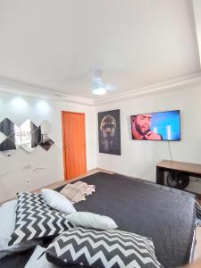a bedroom with a bed and a tv on the wall at Apt próximo ao Consulado in Porto Alegre