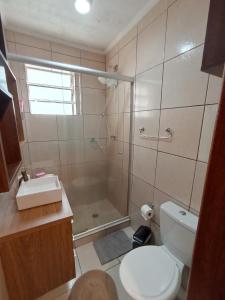 ein Bad mit einer Dusche, einem WC und einem Waschbecken in der Unterkunft Apt próximo ao Consulado in Porto Alegre