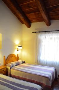 a hotel room with a bed and two lamps at Hostal de Montaña la Casa Grande in Nogueruelas