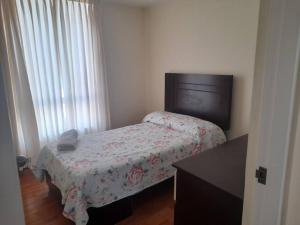 Dormitorio pequeño con cama y vestidor en Encantador apartamento con excelente ubicación, en Lima