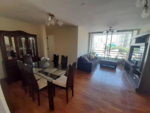 sala de estar con mesa, sillas y sofá en Encantador apartamento con excelente ubicación, en Lima
