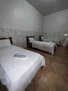 a room with two beds in a room at Hotel Planalto in Conceição do Araguaia