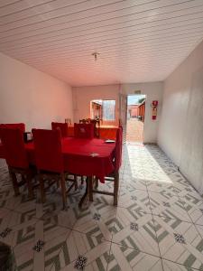 Hotel Planalto في Conceição do Araguaia: غرفة طعام مع طاولة حمراء وكراسي