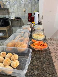 a kitchen counter with trays of food on it at Hotel Planalto in Conceição do Araguaia