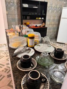 a counter with plates and bowls and glasses on it at Hotel Planalto in Conceição do Araguaia
