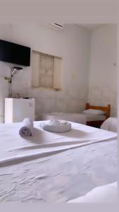a white bed with two pillows on top of it at Hotel Planalto in Conceição do Araguaia