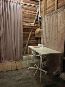 escritorio y silla en una habitación con cortina en La Casita de la Laguna Limón en El Cedro
