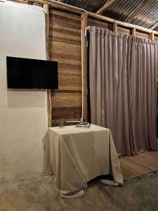 una mesa en una habitación con TV en la pared en La Casita de la Laguna Limón en El Cedro