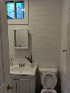 a white bathroom with a toilet and a sink at New Gardenroom 2 Beds (apt4) in Philadelphia