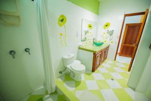 uma casa de banho com piso xadrez amarelo e branco em Galápagos Trip em Puerto Ayora